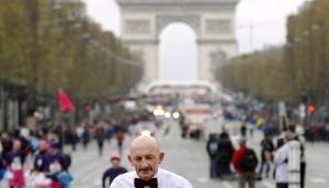 Ein als Kellner gekleideter Läufer balanciert beim Marathon in Paris sein Tablett.