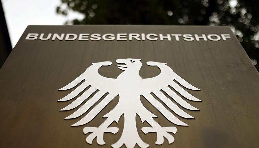 Ein Hinweisschild mit dem Bundesadler steht vor dem Bundesgerichtshof (BGH) in Karlsruhe.