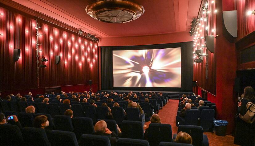 Kinobesucher sitzen zur Premiere des Films &laquo;Komm mit mir in das Cinema - Die Gregors&raquo; mit Masken und Abstand im Delphi-Filmpalast in Berlin.