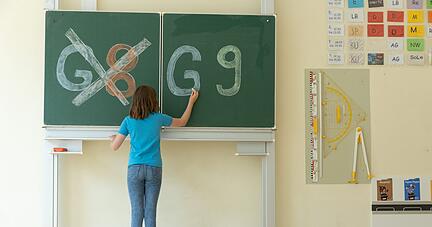 Eine Schülerin einer Schule hat «G8» an einer Tafel durchgestrichen. Eine Schülerin einer Schule hat «G8» an einer Tafel durchgestrichen.
