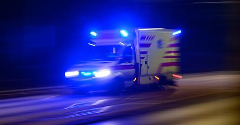 Ein Rettungswagen fährt am Abend mit Blaulicht zum Einsatz. (Aufnahme mit langer Belichtungszeit) Ein Rettungswagen fährt am Abend mit Blaulicht zum Einsatz. (Aufnahme mit langer Belichtungszeit)