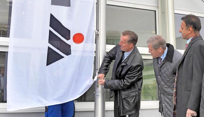 Da packt der Konzernchef persönlich an: Don Walker hisst vor der Untergruppenbacher Getrag-Zentrale die Magna-Fahne. Jake Hirsch (Magna Powertrain) und Mihir Kotecha (Getrag, von links) schauen zu. Foto: Mario Berger Da packt der Konzernchef persönlich an: Don Walker hisst vor der Untergruppenbacher Getrag-Zentrale die Magna-Fahne. Jake Hirsch (Magna Powertrain) und Mihir Kotecha (Getrag, von links) schauen zu. Foto: Mario Berger