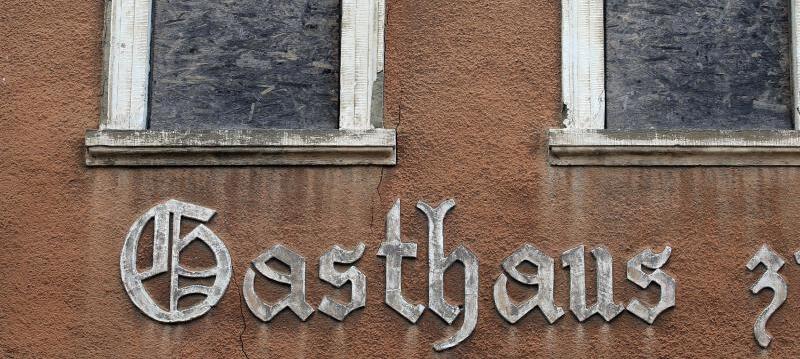 Mit Holzplatten verdeckt sinddie Fenster eines nicht mehr bewirtschafteten Gasthauses. Mit Holzplatten verdeckt sinddie Fenster eines nicht mehr bewirtschafteten Gasthauses.