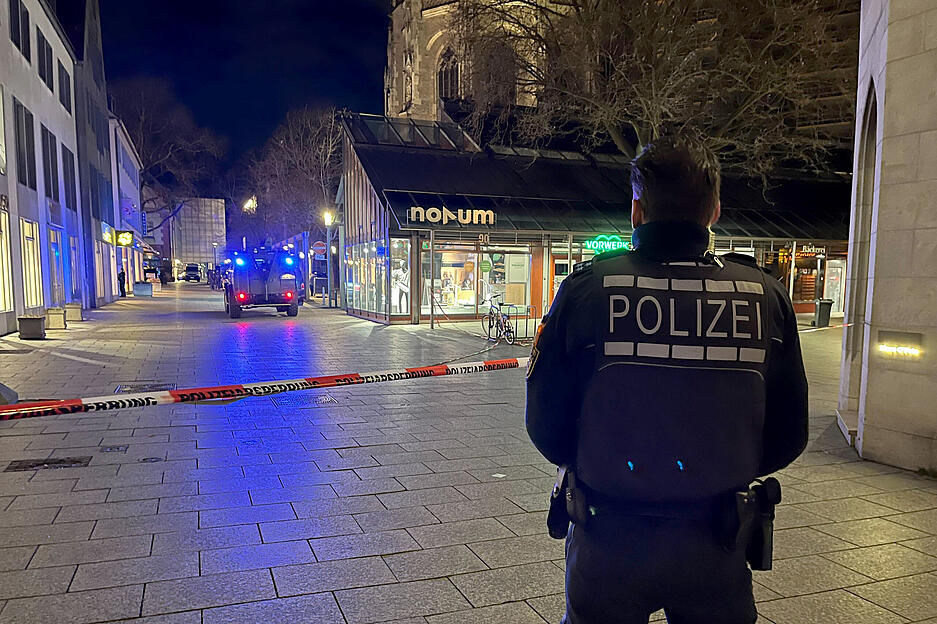 Ein Polizist steht vor einem Absperrband der Polizei am Münsterplatz. Ein Polizist steht vor einem Absperrband der Polizei am Münsterplatz.