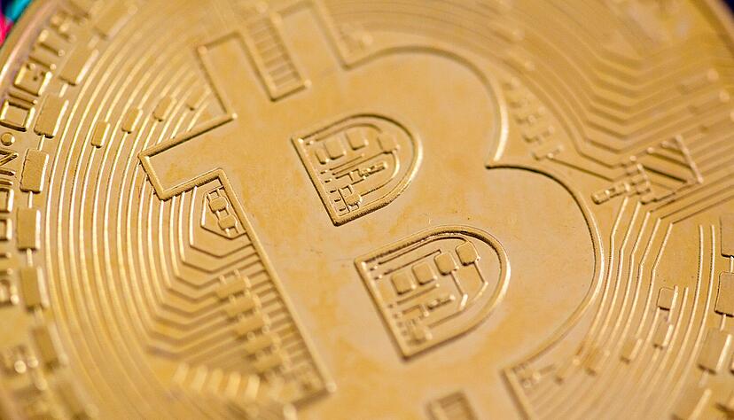 Eine Bitcoin-Münze liegt auf einem Tisch. (Symbolbild) Eine Bitcoin-Münze liegt auf einem Tisch. (Symbolbild)