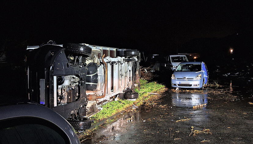Beschädigte Autos und ein umgekippter Laster liegen in Köln neben abgebrochenen Ästen. Beschädigte Autos und ein umgekippter Laster liegen in Köln neben abgebrochenen Ästen.