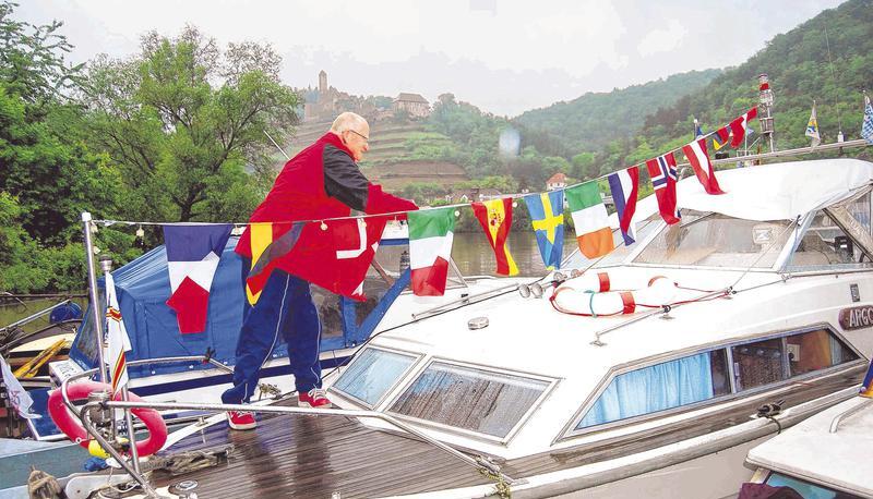 Der Heilbronner Hans Haferkamp flaggt ein Boot trotzt des miesen Wetters, das sein Verein HBV bei der Feier zum 20-j&auml;hrigen Bestehen hinnehmen musste.
Foto: Landauer