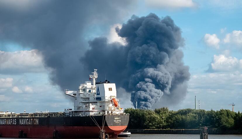 Rauch ist hinter einem Schiff zu sehen; in der N&auml;he des Einsatzortes flie&szlig;t die Norderelbe.