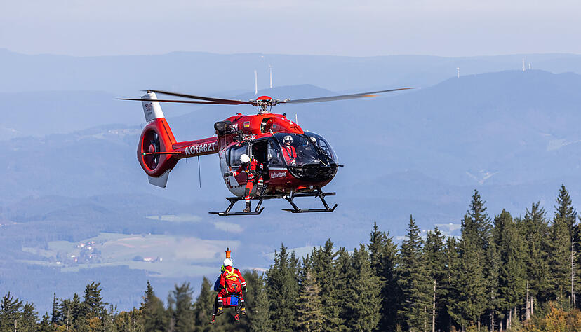 Je ein Mitglied von Bergwacht und DRF Luftrettung hängen an einem Seil unter einem Rettungshubschrauber während im Hintergrund der Schwarzwald zu sehen ist. Während einem Windentraining übt die Besatzung der Freiburger Station der DRF Luftrettung (Rufzeichen Christoph 54) gemeinsam mit der Bergwacht Schwarzwald Einsätze mit der Winde unter einem Helikopter. Mit dieser Winde können sowohl Patienten aus unwegsamem Gelände geborgen wie auch Ärzte und Sanitäter in schwer zugängliche Regionen gebracht werden. +++ dpa-Bildfunk +++