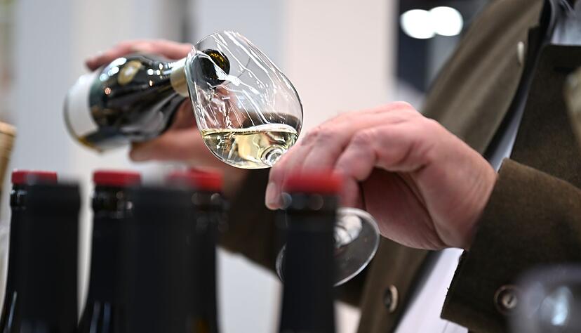 Ein Mitarbeiter des badischen Weinguts Bimmerle gie&szlig;t am Prowein-Messe-Stand seiner Firma Riesling in ein Glas.