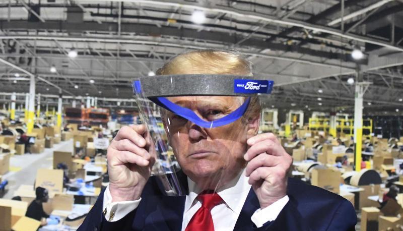 Donald Trump hält während des Rundgangs in einem Ford-Werk ein Gesichtsvisier in den Händen - einen Mundschutz trug er trotz Aufforderung nicht.