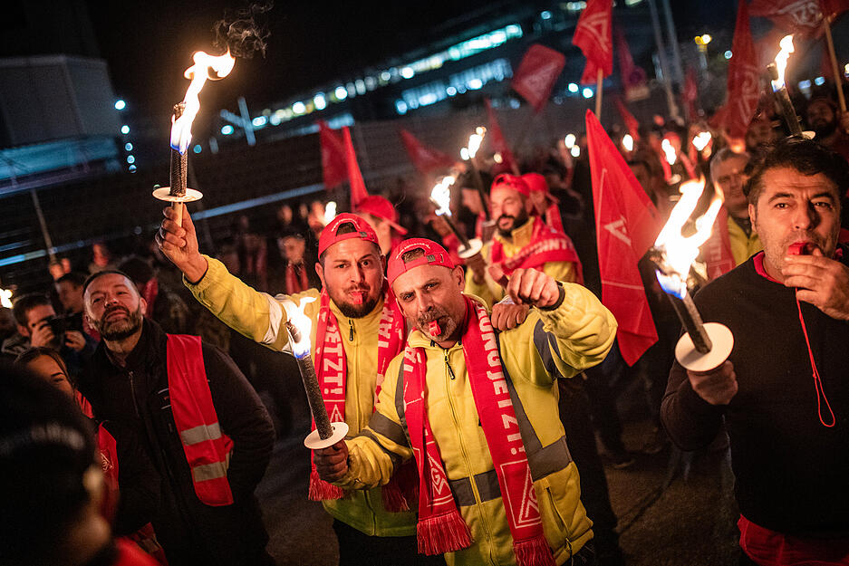 Am Porsche-Werk in Stuttgart ziehen Mitarbeiter mit Fackeln beim Streik umher.