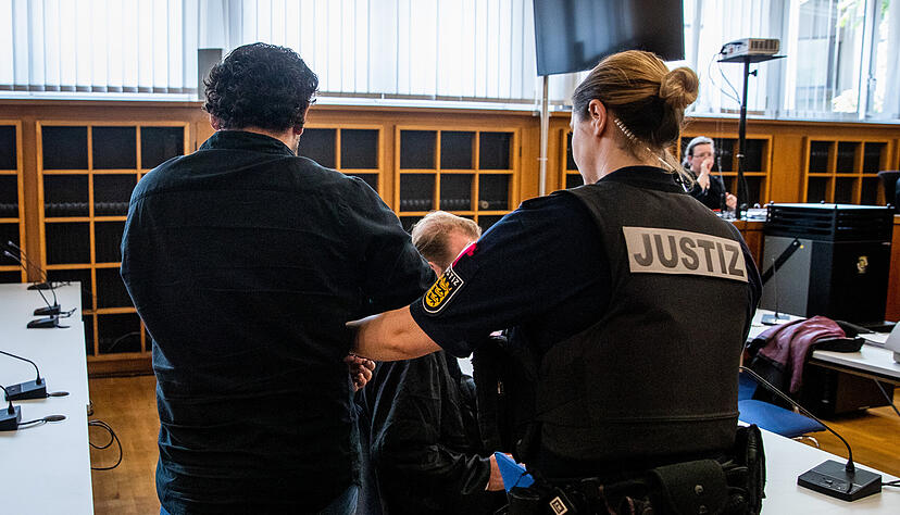 Einer von zwei Angeklagten wird in einem Saal des Landgerichts Heilbronn zu seinem Platz geführt.