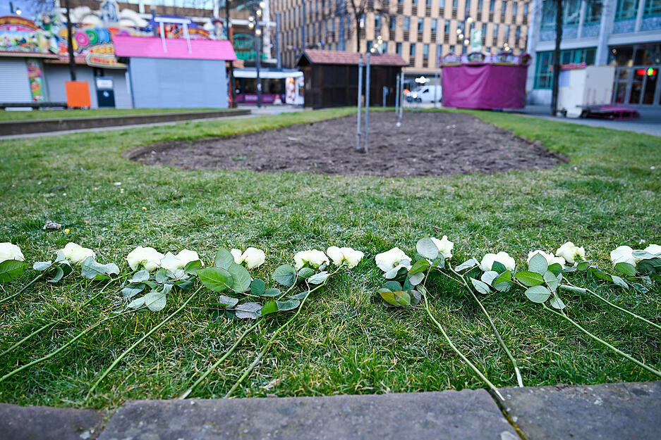 Weiße Rosen liegen in der Nähe des Paradeplatzes auf einer Grünfläche. Weiße Rosen liegen in der Nähe des Paradeplatzes auf einer Grünfläche.