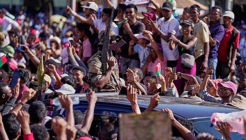 Demonstranten bejubeln Angeh&ouml;rige des Milit&auml;rs auf Madagaskar, als diese den Sturz des Pr&auml;sidenten ank&uuml;ndigen.