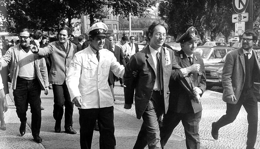 Fritz Teufel (M, ohne Bart), Mitglied der Berliner "Kommune 1", wird nach Tumulten im Sch&ouml;neberger Rathaus am 15. September 1967 abgef&uuml;hrt. Links hinter dem Polizist ist Andreas Baader.