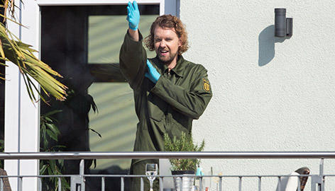 Ein Beamter der Spurensicherung zeigt am Tatort auf einer Veranda mit seinem Arm die mögliche Schussrichtung einer Kugel. Foto: dpa