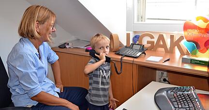 Der sechsjährige Dean geht für Olgakrippenleiterin Monika Karacic ans Telefon. Das Büro ist hier auch ein Raum, den Kinder entdecken dürfen. 
Foto: Stefanie Pfäffle