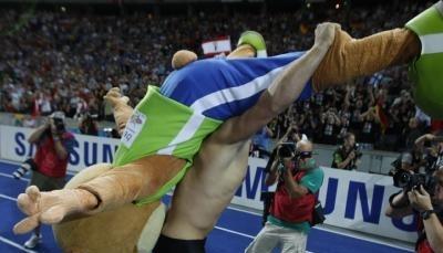 Im ersten &Uuml;berschwang nach dem Sieg schultert Robert Harting auch Maskottchen Berlino.