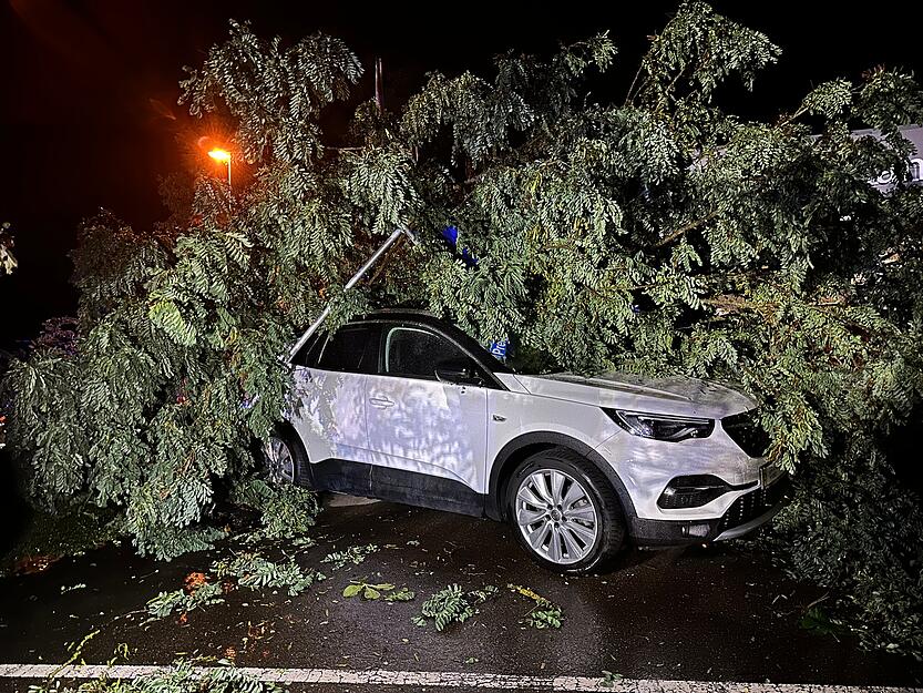 Ein umgestürzter Baum liegt nach einem Unwetter in Sigmaringen auf einem Auto. Ein umgestürzter Baum liegt nach einem Unwetter in Sigmaringen auf einem Auto.