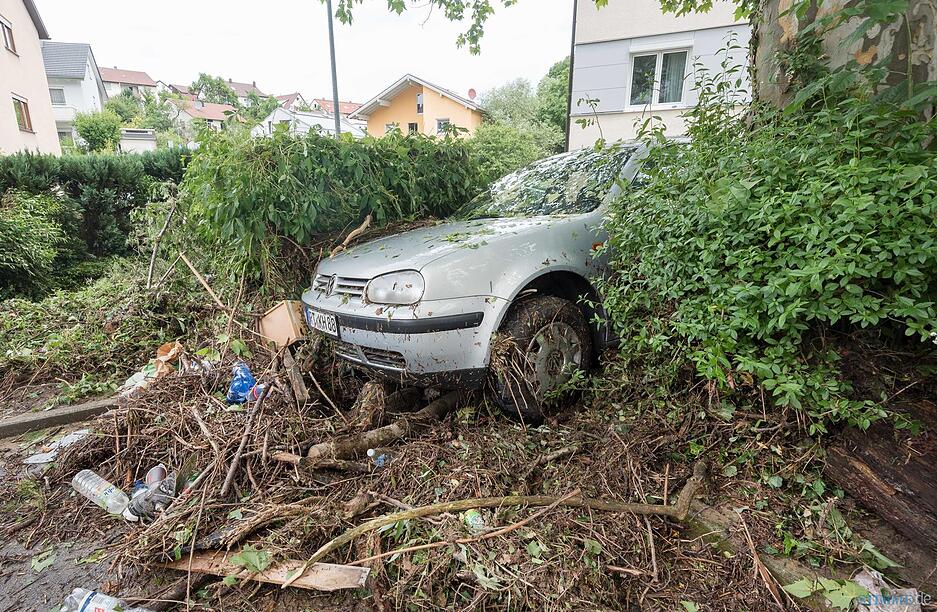 dpatopbilder - Ein Auto liegt am 25.06.2016 in Pfullingen (Baden-W&uuml;rttemberg) nach der &Uuml;berflutung der Echatz zwischen weggesp&uuml;ltem Unrat. Nach unwetterartigem Regen am Samstagabend sind der Eierbach und die Echatz &uuml;ber die &Uuml;fer getreten. Foto: Daniel Maurer/dpa +++(c) dpa - Bildfunk+++ | Verwendung weltweit