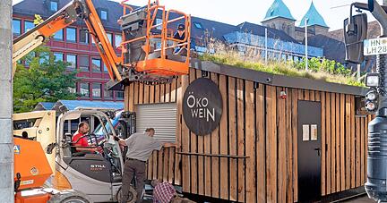 Mit vereinten Kräften platzierten am Montag die Öko-Winzer am Marktplatz ihren Weinstand. Am Donnerstag muss alles fertig sein.
Foto: Mario Berger
