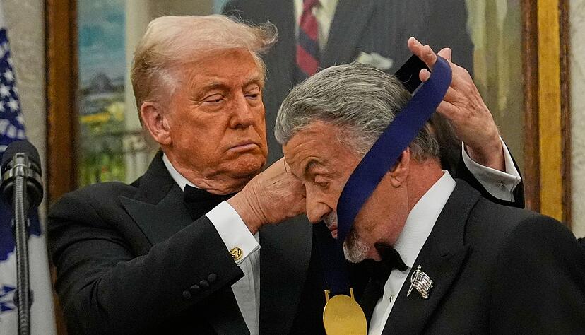 US-Präsident Donald Trump hängt der Actionfilm-Ikone Sylvester Stallone eine Medaille um. US-Präsident Donald Trump hängt der Actionfilm-Ikone Sylvester Stallone eine Medaille um.