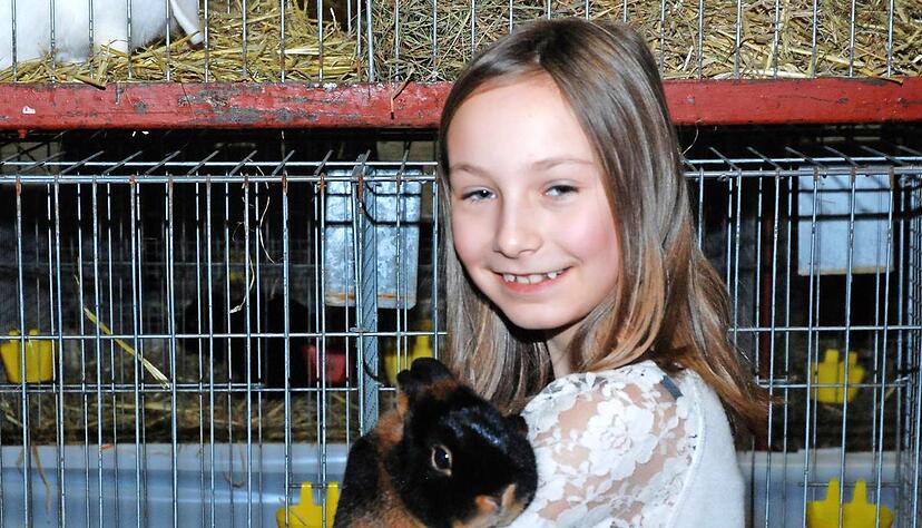 Die zehnj&auml;hrige Shirin h&auml;lt bei der Ausstellung ihren kuscheligen Farbenzwerg lohfarbig-schwarz auf dem Arm.Foto: Josef Staudinger