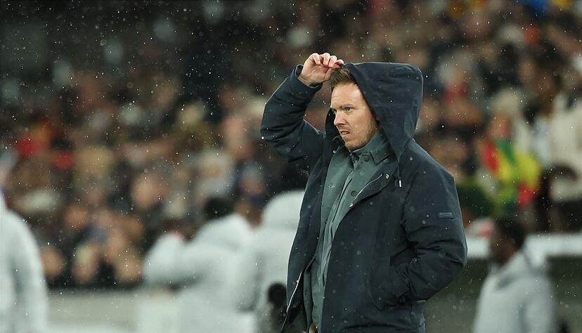 Julian Nagelsmann zieht sich im Regen eine Kapuze über den Kopf. Julian Nagelsmann zieht sich im Regen eine Kapuze über den Kopf.