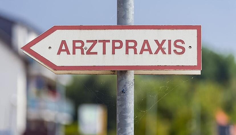 Ein Schild «Arztpraxis» steht an der Straße. Ein Schild «Arztpraxis» steht an der Straße.