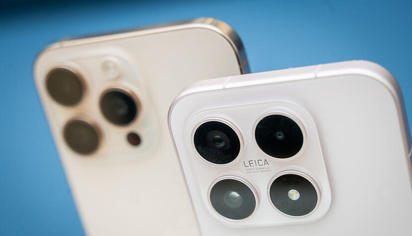 Apple verlangt einen Aufpreis f&uuml;r eine dedizierte Teleobjektivlinse bei seinen Pro-iPhones (im Hintergrund), w&auml;hrend Xiaomi in seinem Basismodell Xiaomi 17 (im Vordergrund) ein Zoomobjektiv standardm&auml;&szlig;ig integriert.