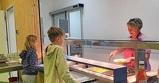 Die Kinder lassen sich Cevapcici mit Paprikasoße und Kartoffelwedges schmecken. Wer keine Soße möchte, kann sich einen Klecks Ketchup nehmen.
Foto: Sarah Arweiler