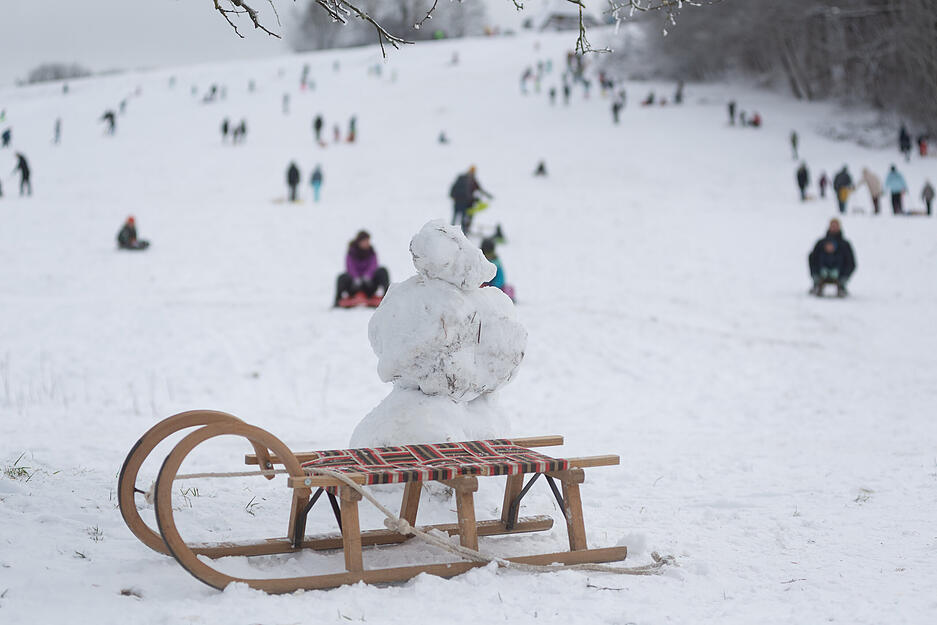 Der schneebedeckte Hang wird schnell zu einem beliebten Winterspielplatz.