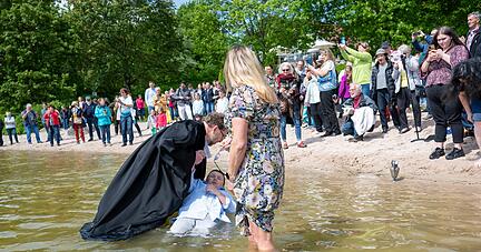 Während Pfarrer Grützmacher vorsichtig Cailans Kopf ins Wasser taucht, hält seine Mama die Brille trocken. Das Tauffest am Breitenauer See kommt gut an.
Foto: Kunz Während Pfarrer Grützmacher vorsichtig Cailans Kopf ins Wasser taucht, hält seine Mama die Brille trocken. Das Tauffest am Breitenauer See kommt gut an.
Foto: Kunz