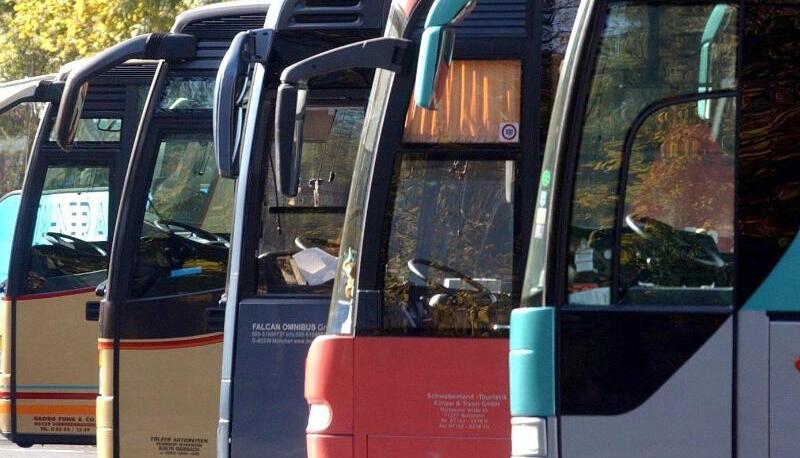 Auf einem Parkplatz stehen mehrere Omnibusse. Auf einem Parkplatz stehen mehrere Omnibusse.