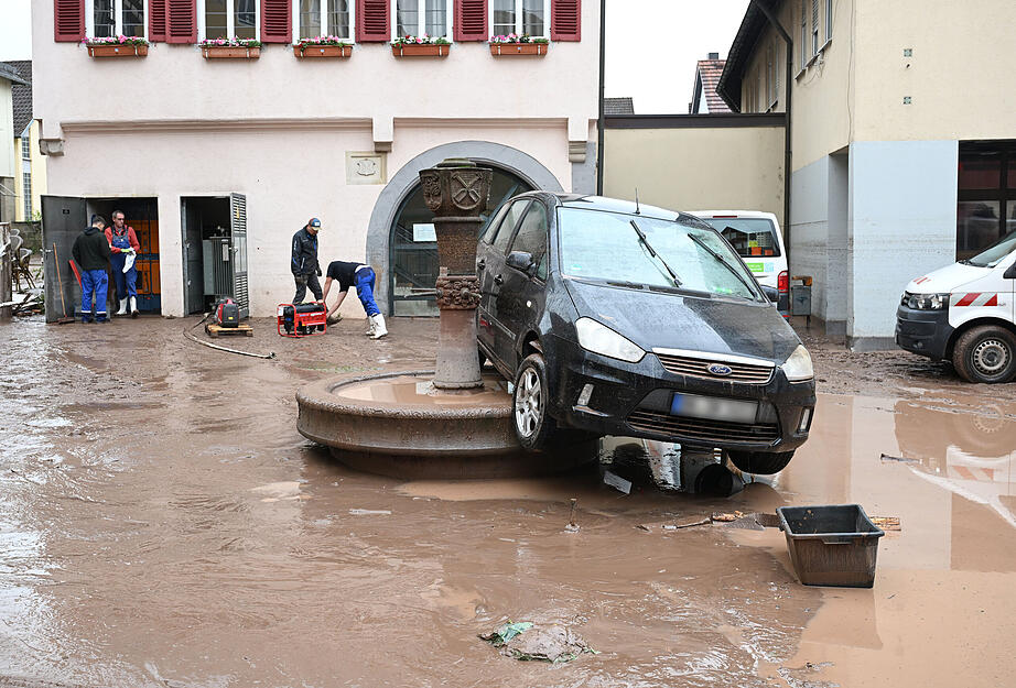 Auf einem Brunnen in Rudersberg steht ein durch ein Hochwasser weggespültes Auto. Auf einem Brunnen in Rudersberg steht ein durch ein Hochwasser weggespültes Auto.