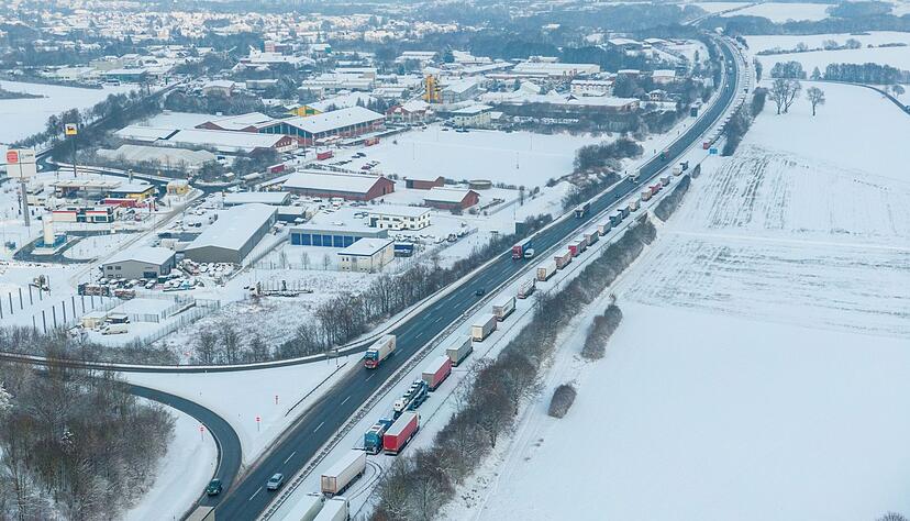 LKW auf der Autobahn A5 Richtung Norden stehen bei Schnee und Eis im Stau.