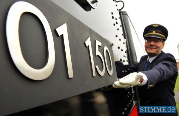 Zugf&uuml;hrer Wolfgang Ihrlich steht am Lokschild der Dampflok 01 150.