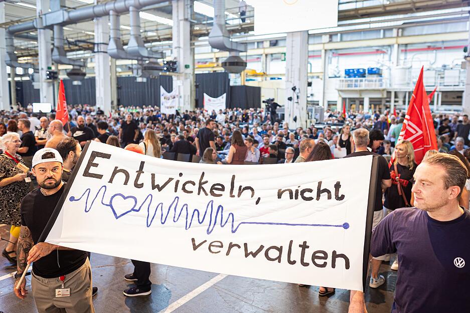 "Entwickeln, nicht verwalten" heißt es auf einem Transparent, das VW-Mitarbeiter hochhalten.