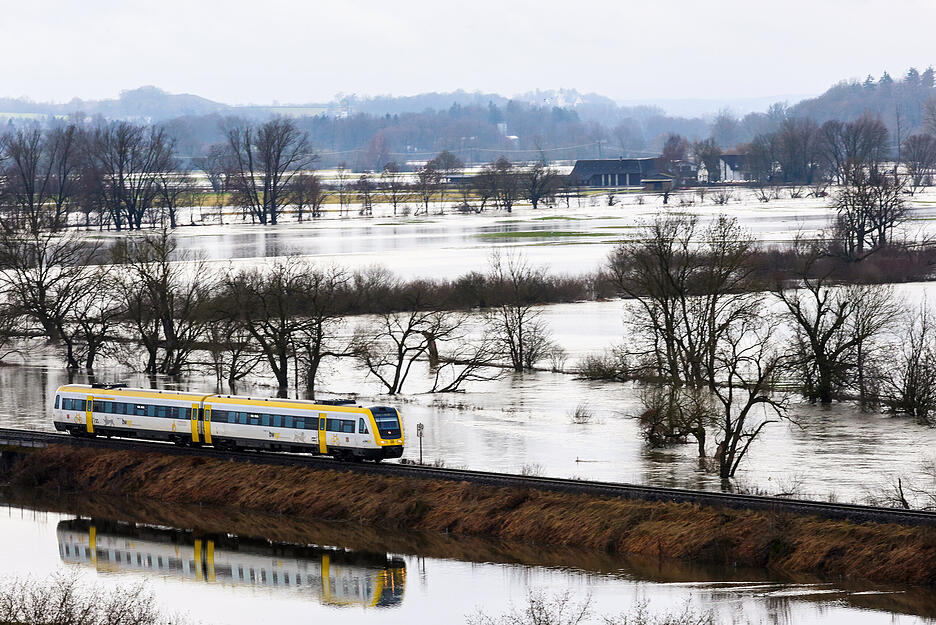 Ein Zug fährt bei Riedlingen durch ein von der Donau überflutetes Gebiet.