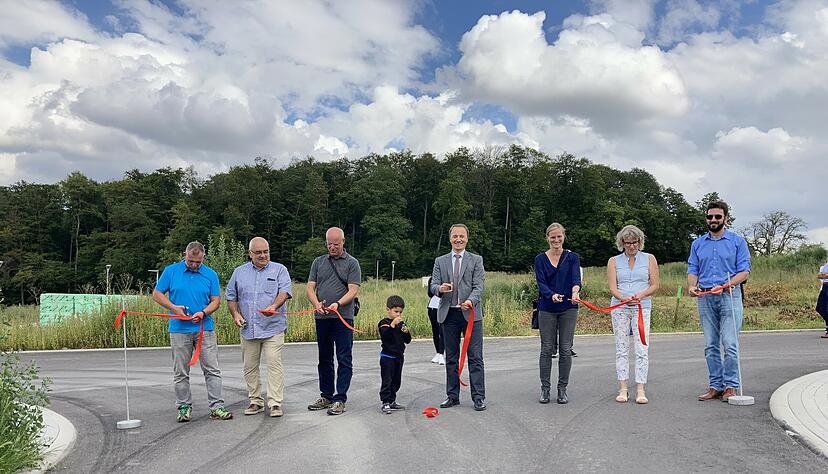 Bürgermeister Gerd Kreiter (Mitte), Bauamtsleiter Michael Baumgartner (links), verantwortliche Projektleiter sowie der baldige Bewohner Gabriel (4) durchschneiden das über die Einfahrt von der Waldstraße symbolisch gespannte Band.
Foto: Schwarzbürger
