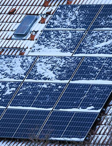 Schnee auf Solarmodulen kann im Winter den Stromertrag mindern: Doch das Abfegen von Schnee birgt Unfallgefahr und kann die empfindlichen Module besch&auml;digen.