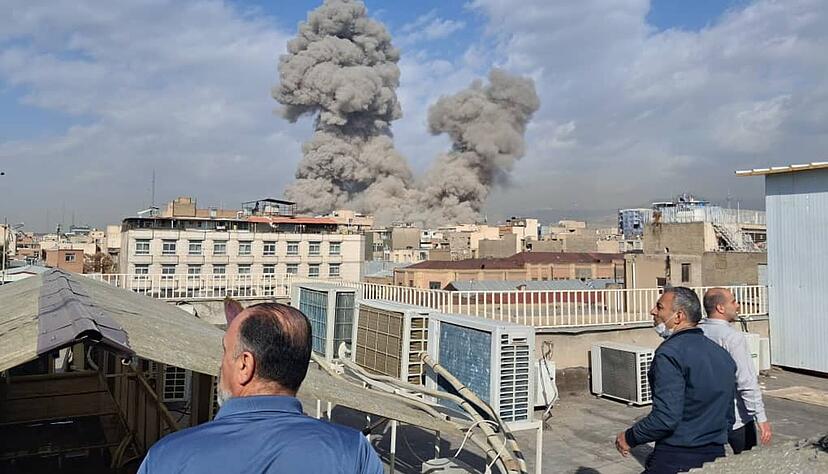 Menschen beobachten Rauch nach einer Explosion in Teheran. (zu dpa: &laquo;Panik in Teheran: Massen fl&uuml;chten aus der Stadt&raquo;)