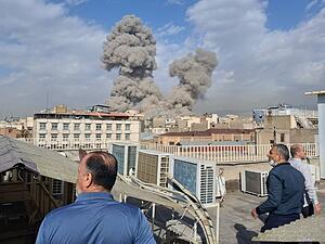 Menschen beobachten Rauch nach einer Explosion in Teheran. (zu dpa: &laquo;Panik in Teheran: Massen fl&uuml;chten aus der Stadt&raquo;)