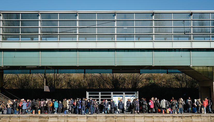 Geflüchtete aus der Ukraine warten an einem überfüllten Bahnsteig auf die Weiterfahrt zum Hauptbahnhof.