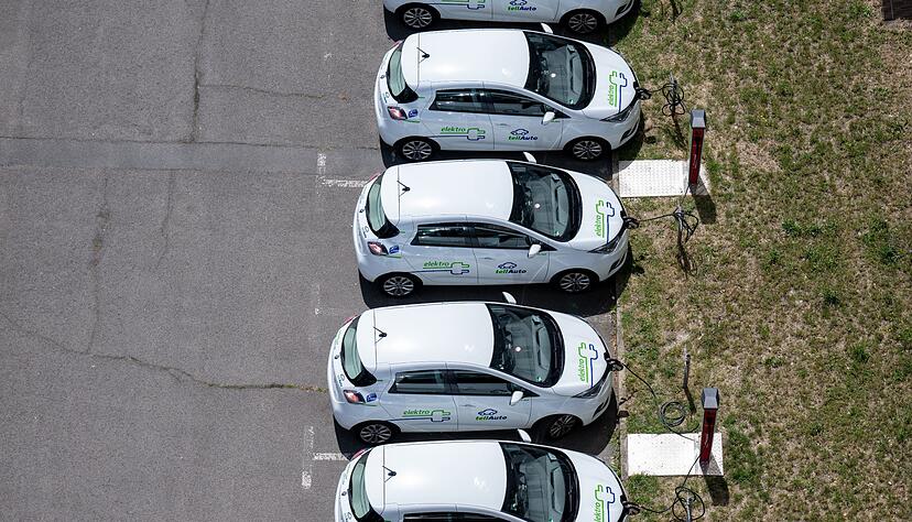 Elektroautos eines Carsharing-Anbieters laden auf einem Parkplatz in Halle/Saale.