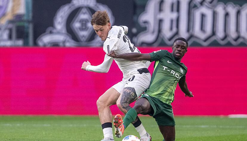Grün gegen Weiß: Wolfsburgs Saël Kumbedi (r) im Zweikampf mit dem Gladbacher Luca Netz. Grün gegen Weiß: Wolfsburgs Saël Kumbedi (r) im Zweikampf mit dem Gladbacher Luca Netz.