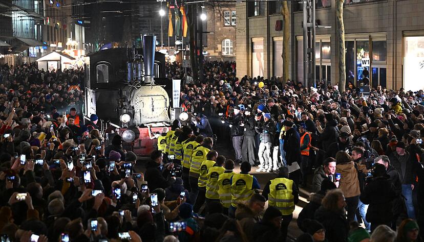 Unter den Augen vieler Zuschauer ziehen Freiwillige die rund 20 Tonnen schwere Dampflokomotive &laquo;Hegel&raquo; im Zentrum von Chemnitz.