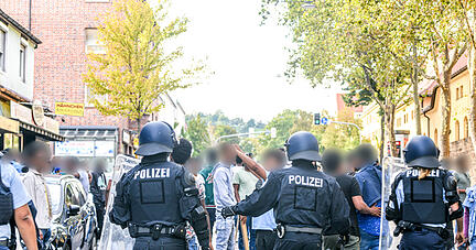 Eine Gruppe von Menschen wird nach Ausschreitungen bei einer Eritrea-Veranstaltung von Polizeikräften eingekesselt.