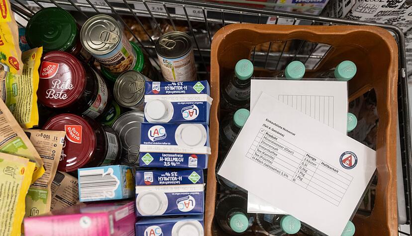 Beim Einkauf für eine vierköpfige Familie landen kiloweise Konserven und literweise Milch im Einkaufswagen. Beim Einkauf für eine vierköpfige Familie landen kiloweise Konserven und literweise Milch im Einkaufswagen.